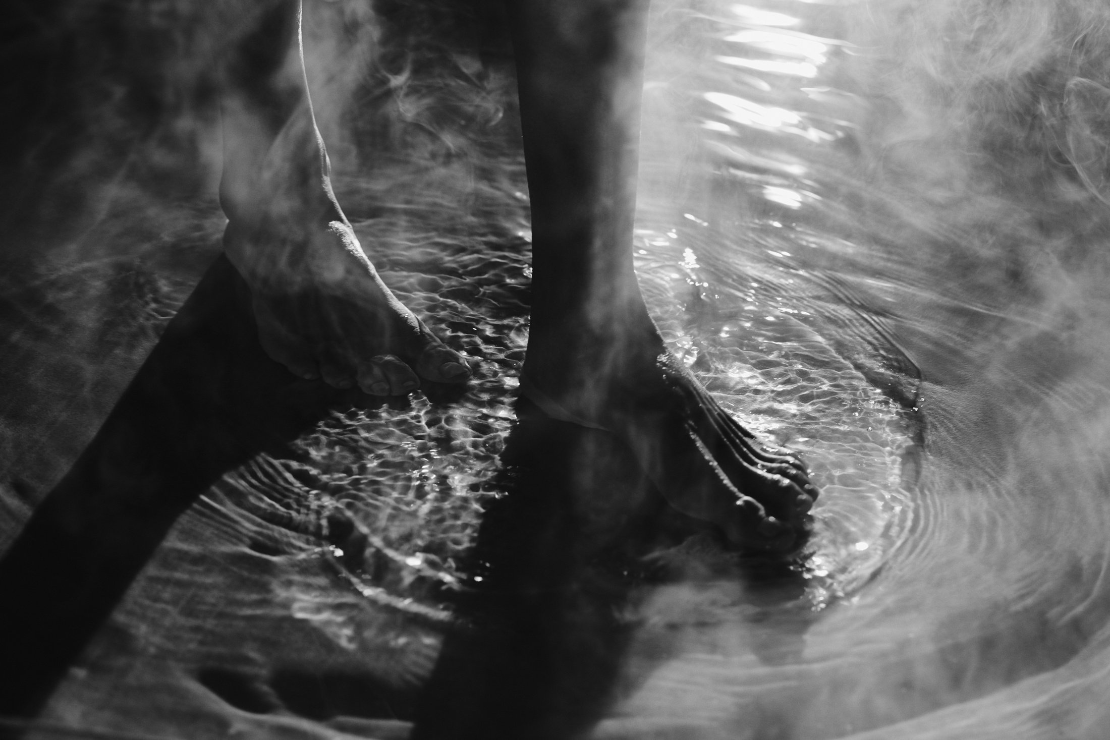 Feet stepping into glacial-fed waters at Basin Glacial Waters